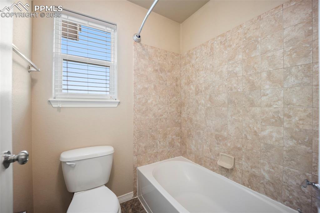 Image 25 of 39: Bathroom with toilet and shower / washtub combination