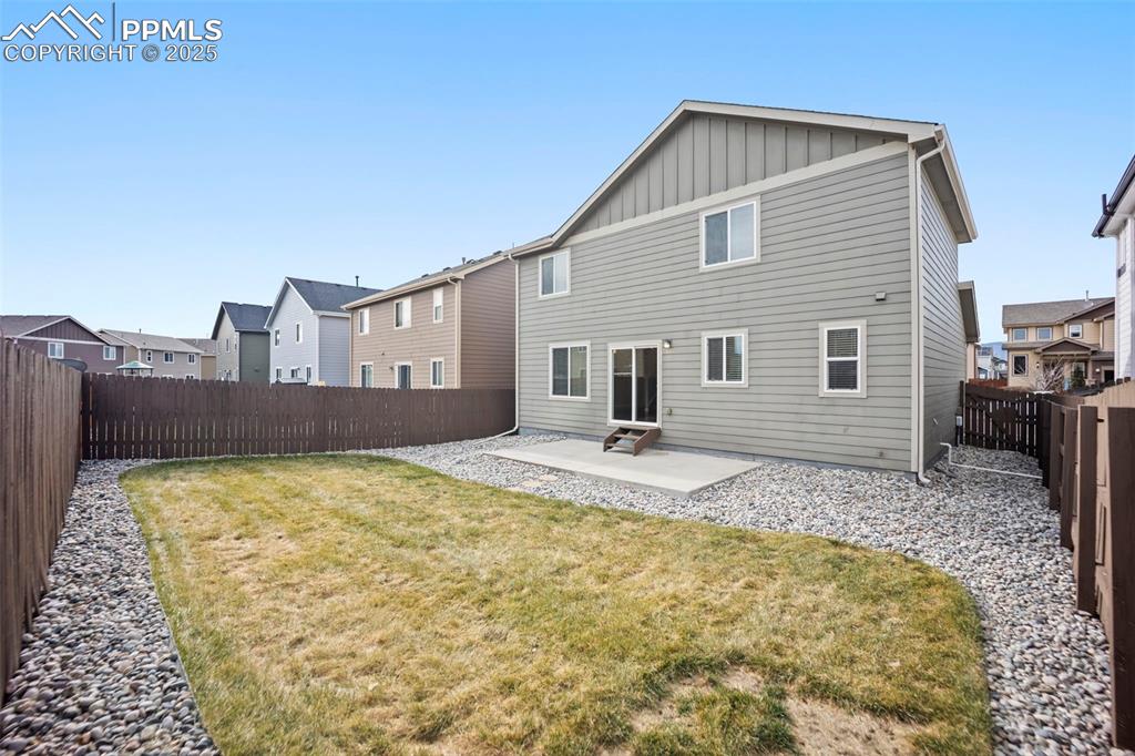 Image 32 of 39: Rear view of property featuring a patio, board and batten siding, a fenced 