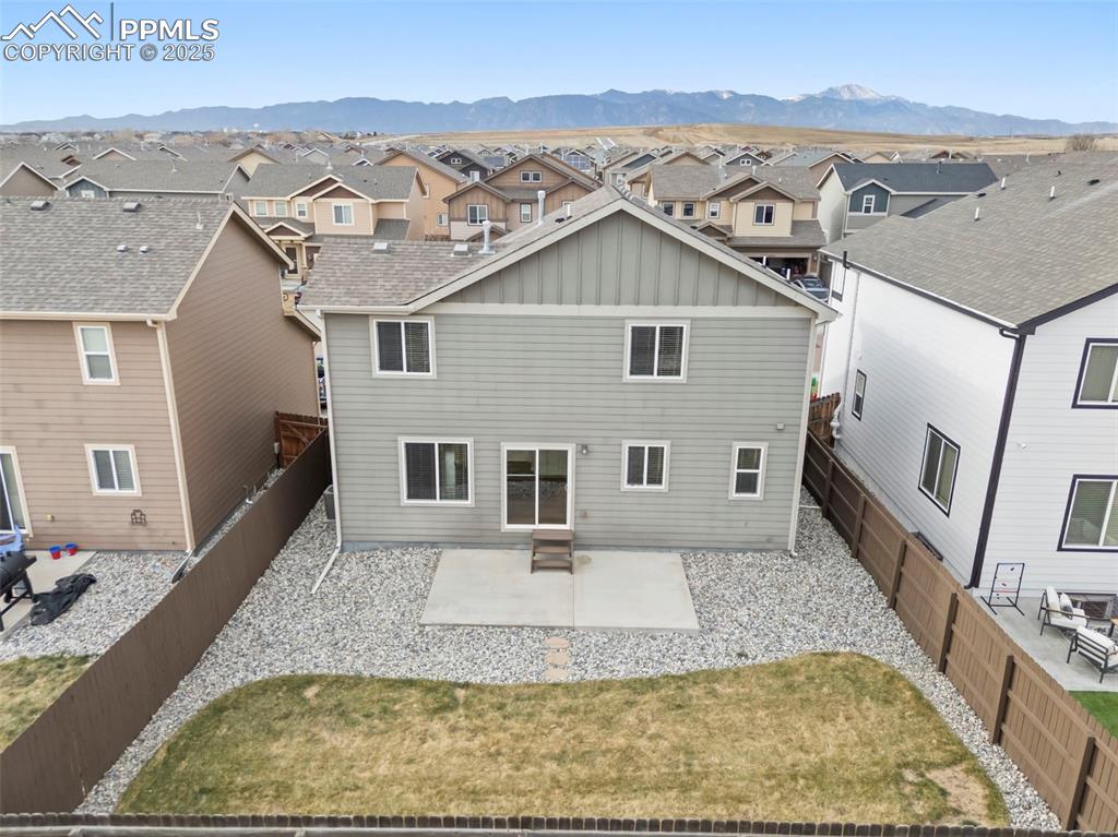 Image 36 of 39: Rear view of house with a patio, board and batten siding, a residential vie