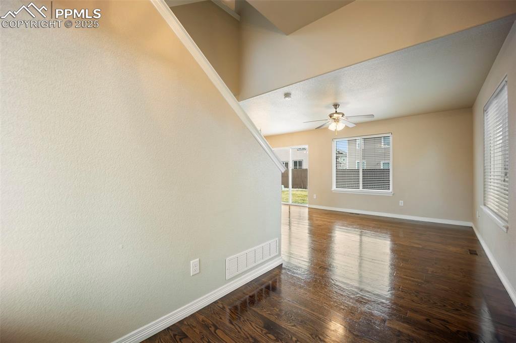 Image 5 of 39: Unfurnished room with dark wood-style floors and a ceiling fan