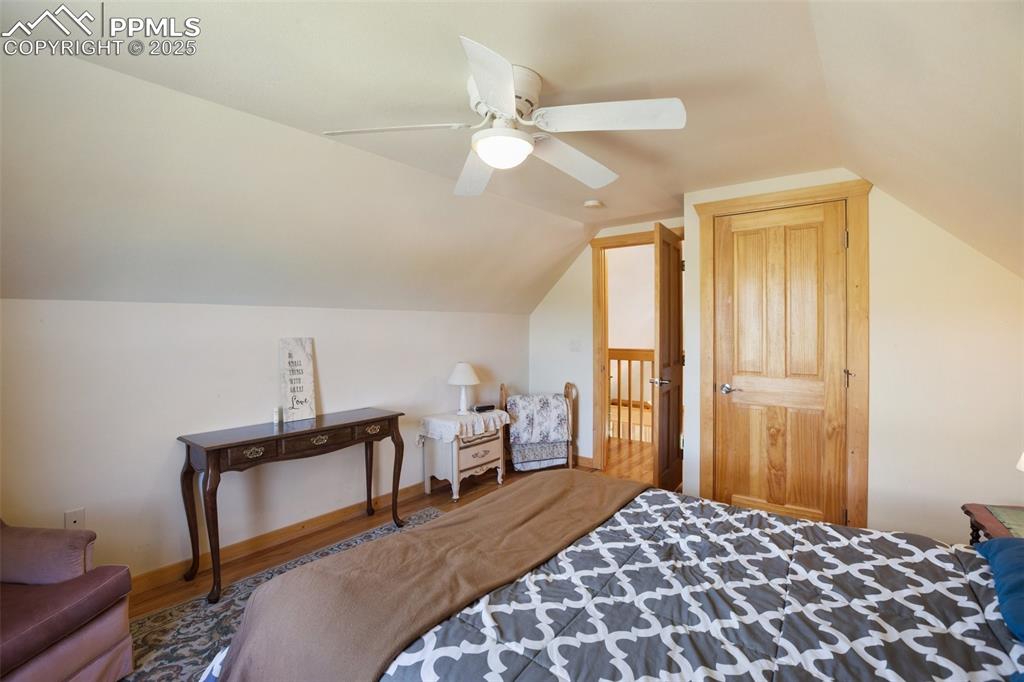 Image 16 of 28: Upper level Bedroom with vaulted ceiling, wood finished floors, and a ceili