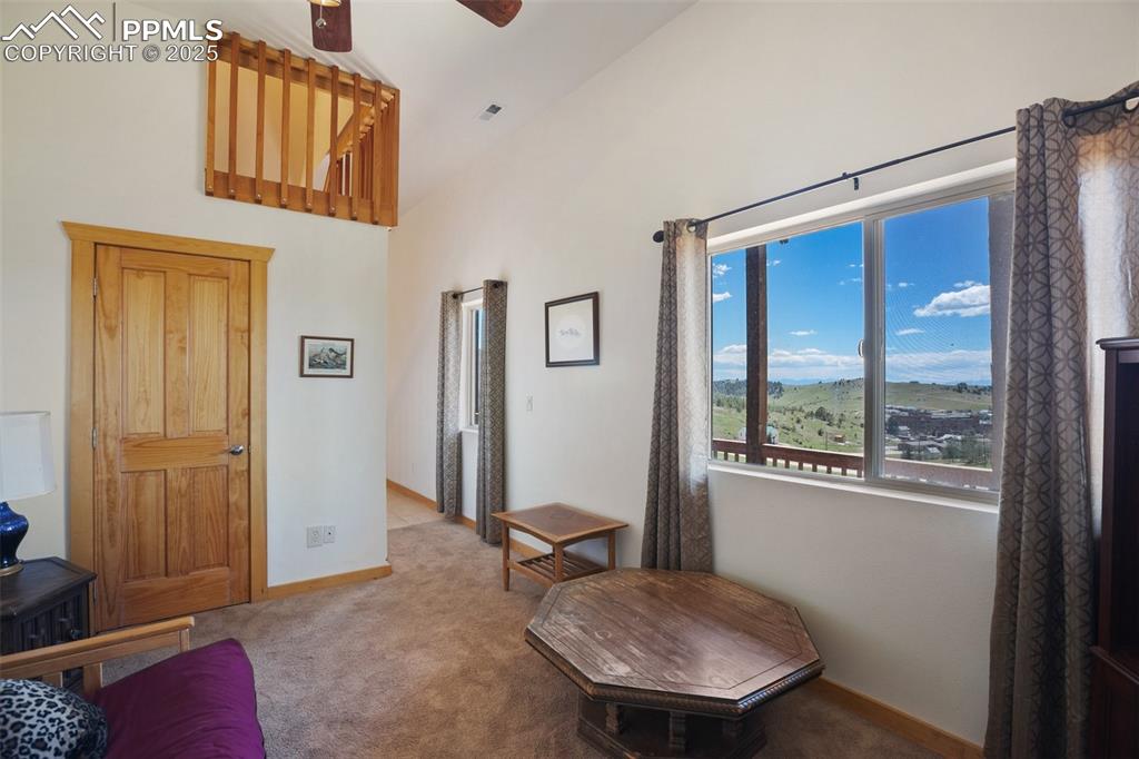 Image 3 of 28: Family room with carpet flooring, high vaulted ceiling, and a ceiling fan