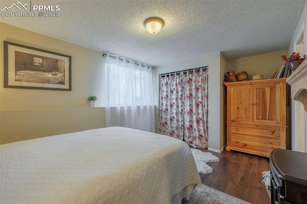 Image 15 of 16: Bedroom with dark wood-style flooring and a textured ceiling