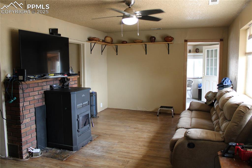 Image 12 of 41: Living room featuring light wood floors, a textured ceiling, and a ceiling 