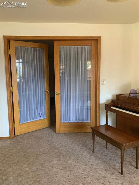 Image 32 of 43: Doorway to outside with carpet flooring