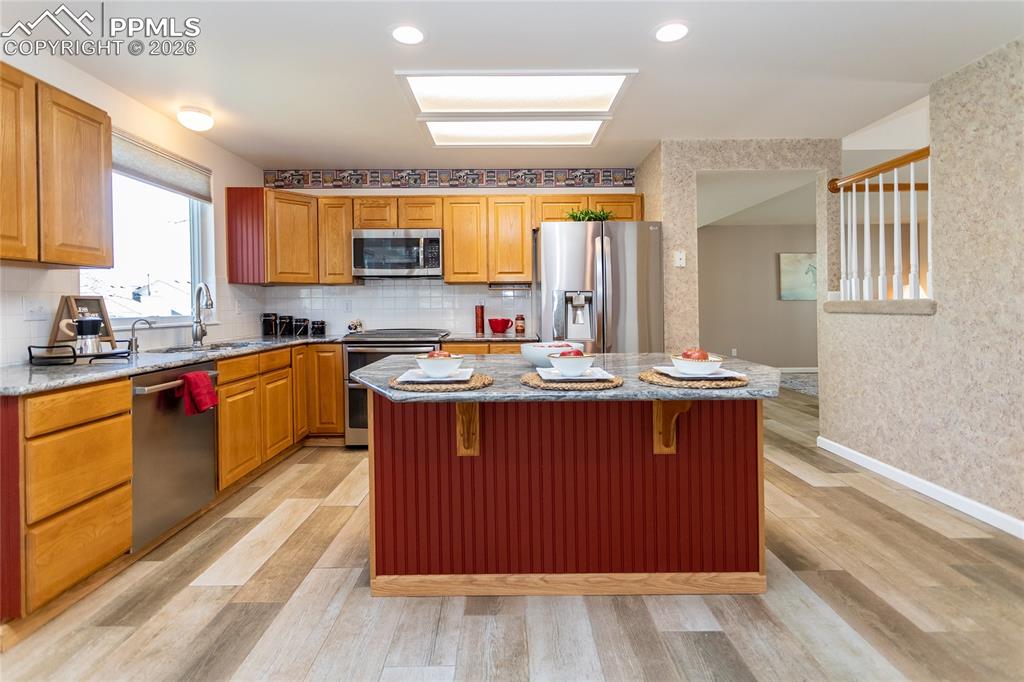 Image 15 of 50: Again, extensive woodlook tile flooring is warmly welcoming.