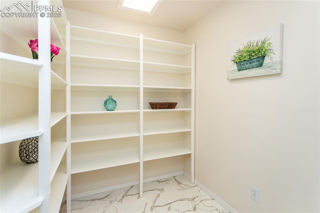 Image 41 of 50: This huge pantry has marble-look LVP floors and tons of storage!