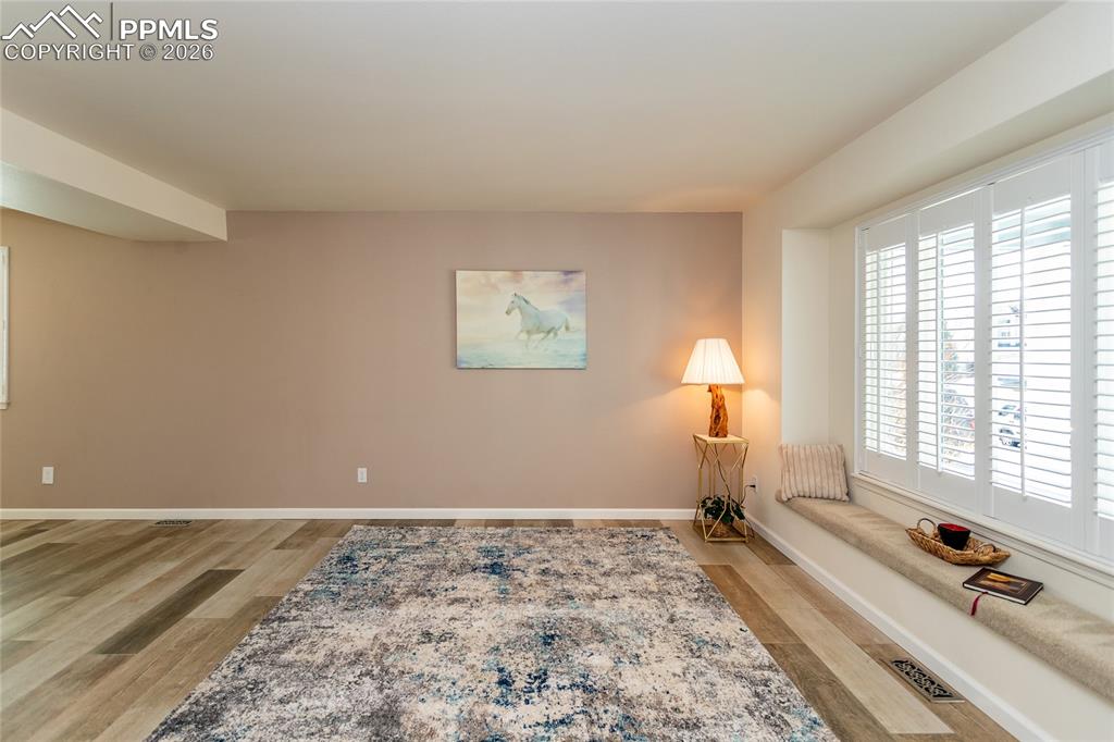 Image 6 of 50: Large living room with window seat for relaxing and watching the world