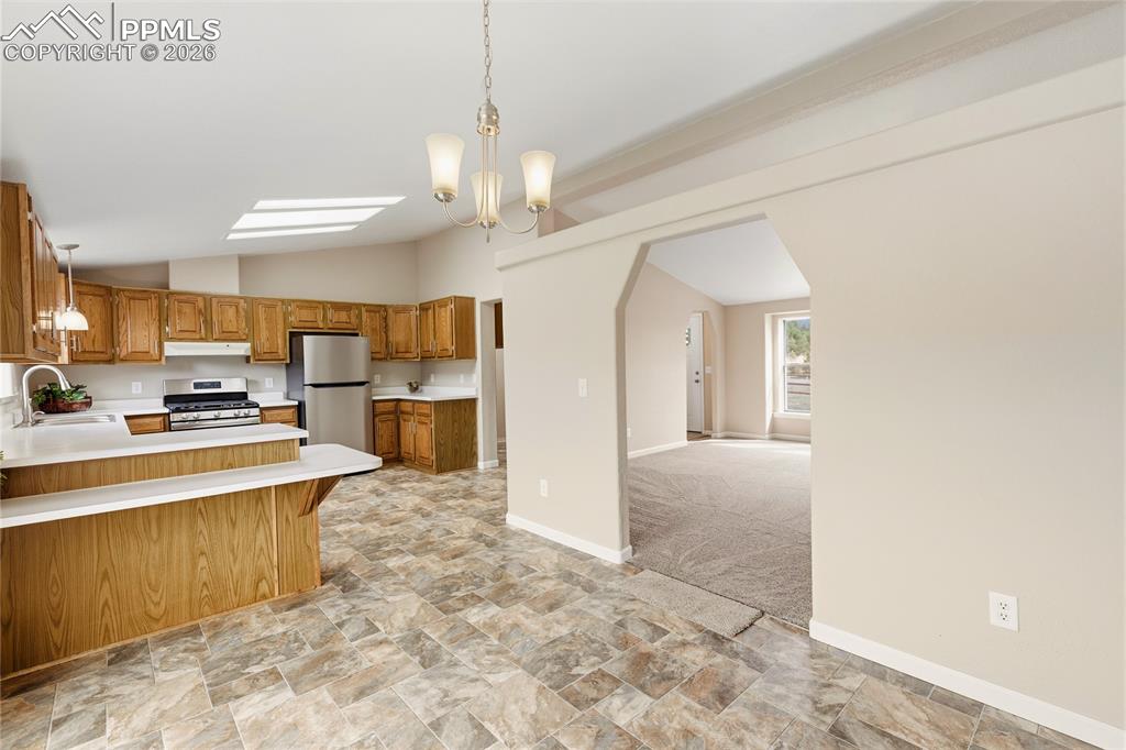Image 24 of 46: Kitchen with light countertops, stone finish flooring, wood finish cabinets