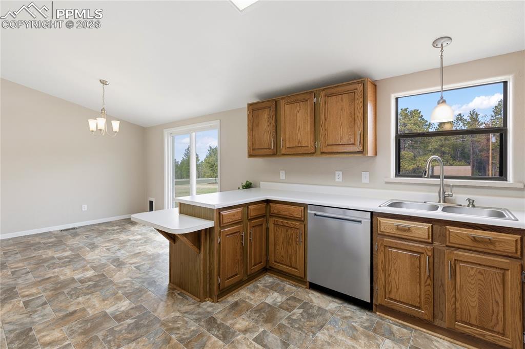 Image 27 of 46: Kitchen with stone finish flooring, light countertops, wood finish cabinetr