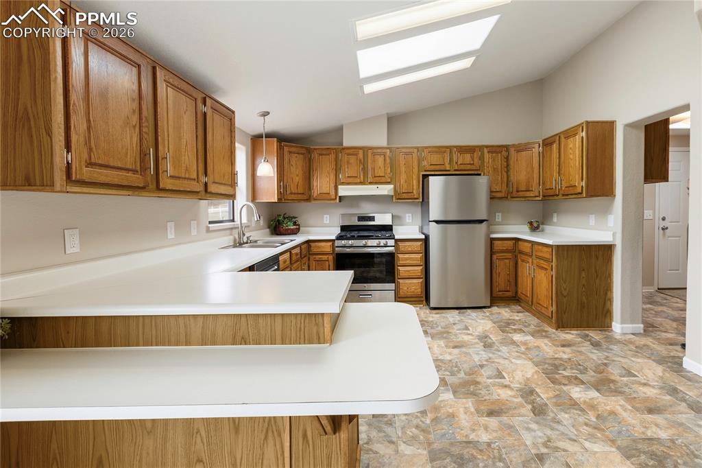 Image 28 of 46: Kitchen featuring stone finish flooring, wood finish cabinetry, stainless s