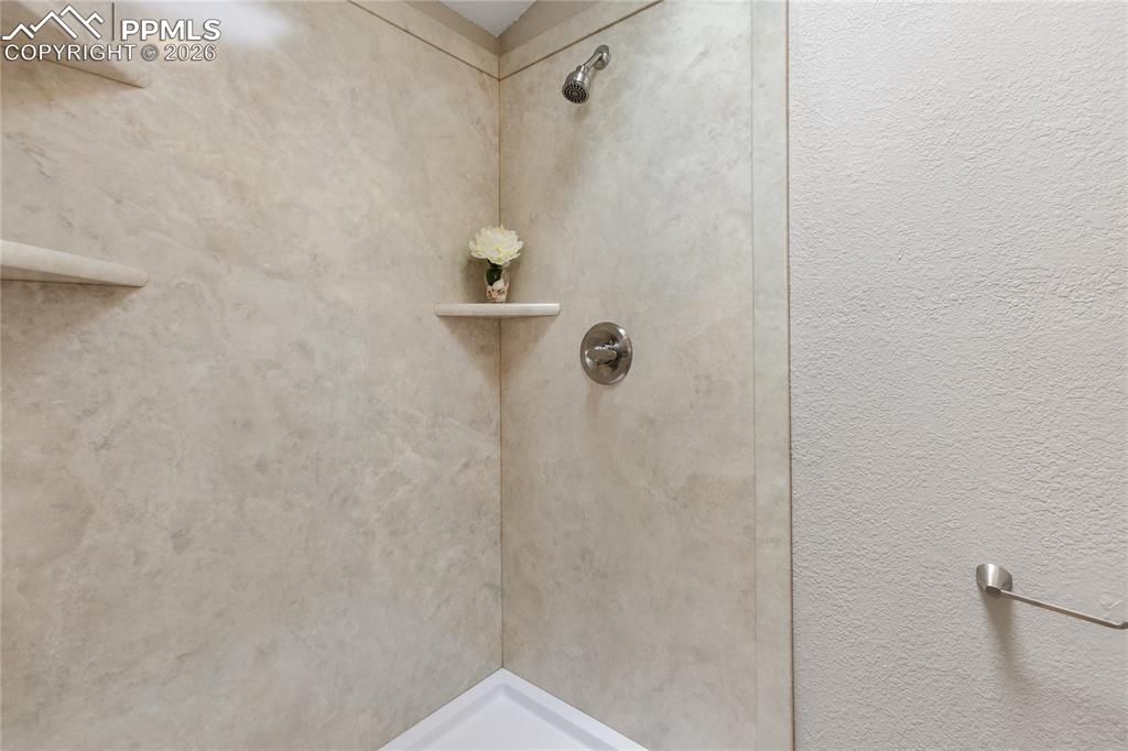 Image 37 of 46: Full bathroom featuring a stall shower and a textured wall