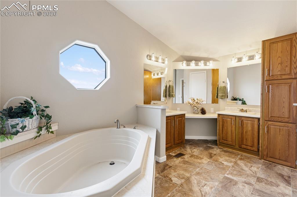 Image 38 of 46: Bathroom featuring two vanities and a bath