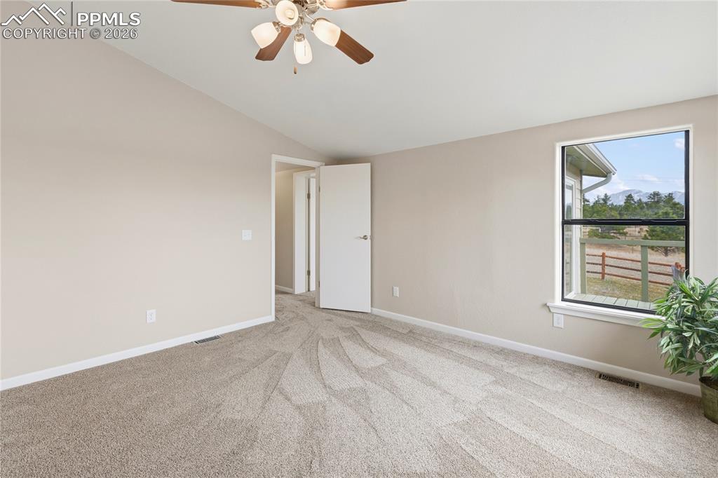 Image 41 of 46: Empty room featuring ceiling fan, light carpet, and vaulted ceiling