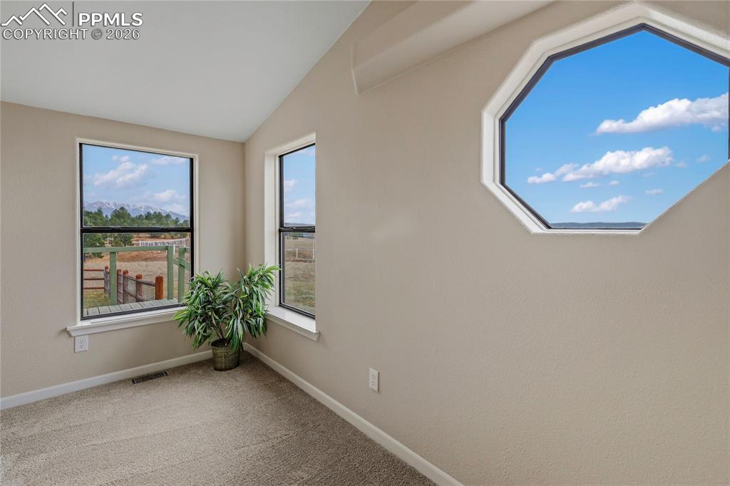 Image 42 of 46: Unfurnished room featuring vaulted ceiling and light colored carpet