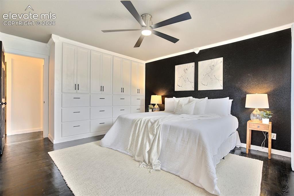 Image 18 of 43: Extensive wall-to-wall white built-in cabinetry, dark wood-finish flooring,