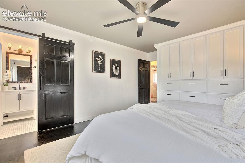 Image 19 of 43: Floor-to-ceiling built-in white cabinetry, matte black sliding barn door, d