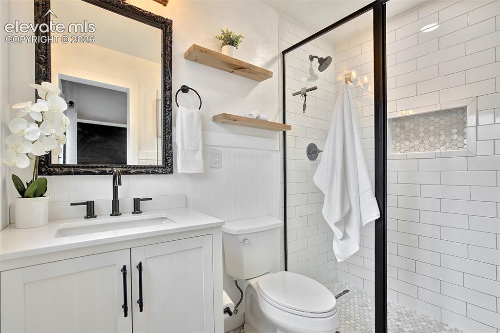 Image 20 of 43: Bathroom featuring a white vanity with a rectangular sink, matte black fixt