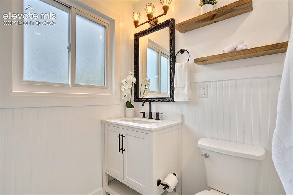 Image 21 of 43: Bathroom featuring a white vanity with a composite countertop, matte black