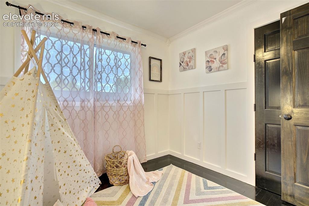 Image 23 of 43: Room featuring wood-finish flooring, white board-and-batten wall detailing,
