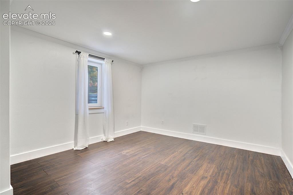 Image 36 of 43: Room featuring dark wood-finish flooring, recessed lighting, and a single w