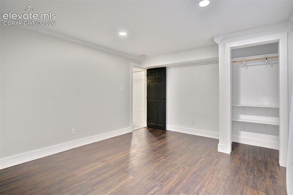 Image 37 of 43: Room interior featuring wood-finish flooring, recessed lighting, crown mold