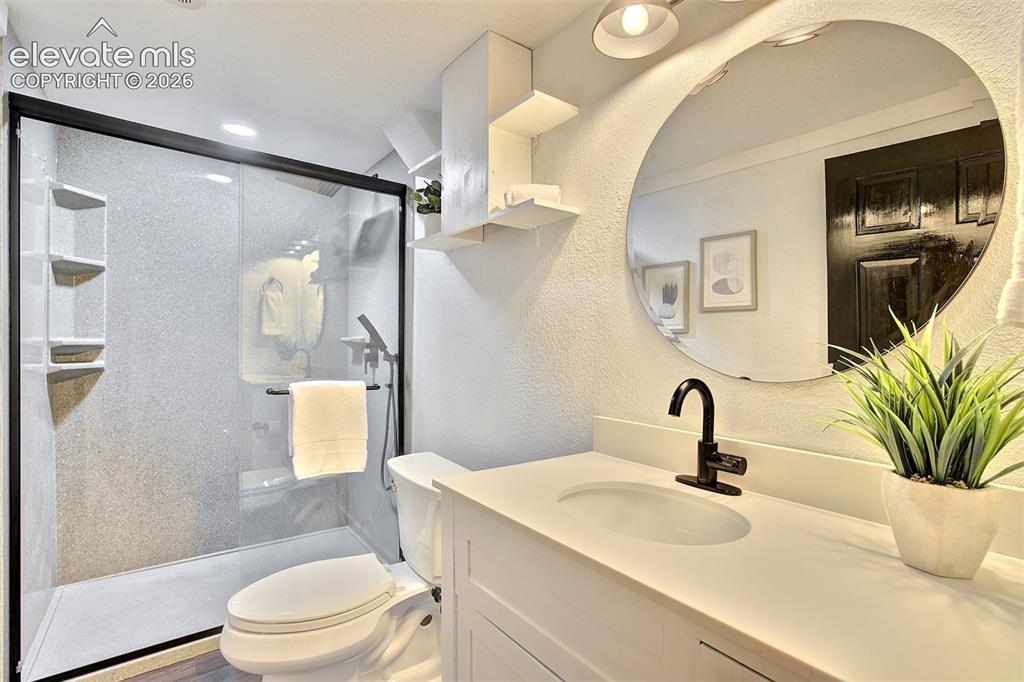 Image 39 of 43: Bathroom featuring a walk-in shower with black-frame glass enclosure, custo