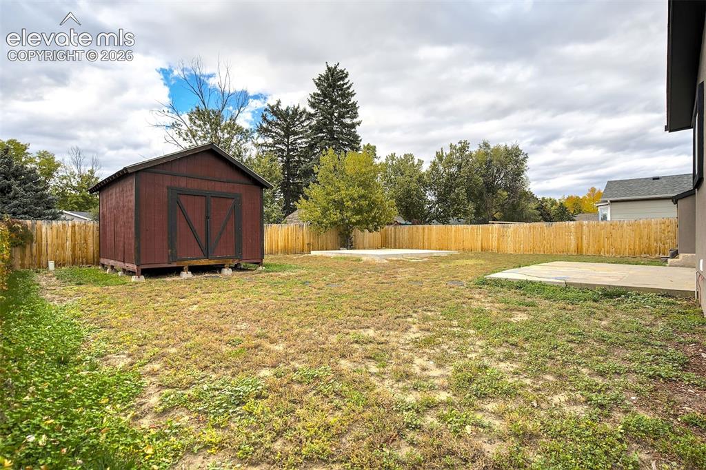 Image 43 of 43: Backyard featuring a wood-panel privacy fence, a detached storage shed, and