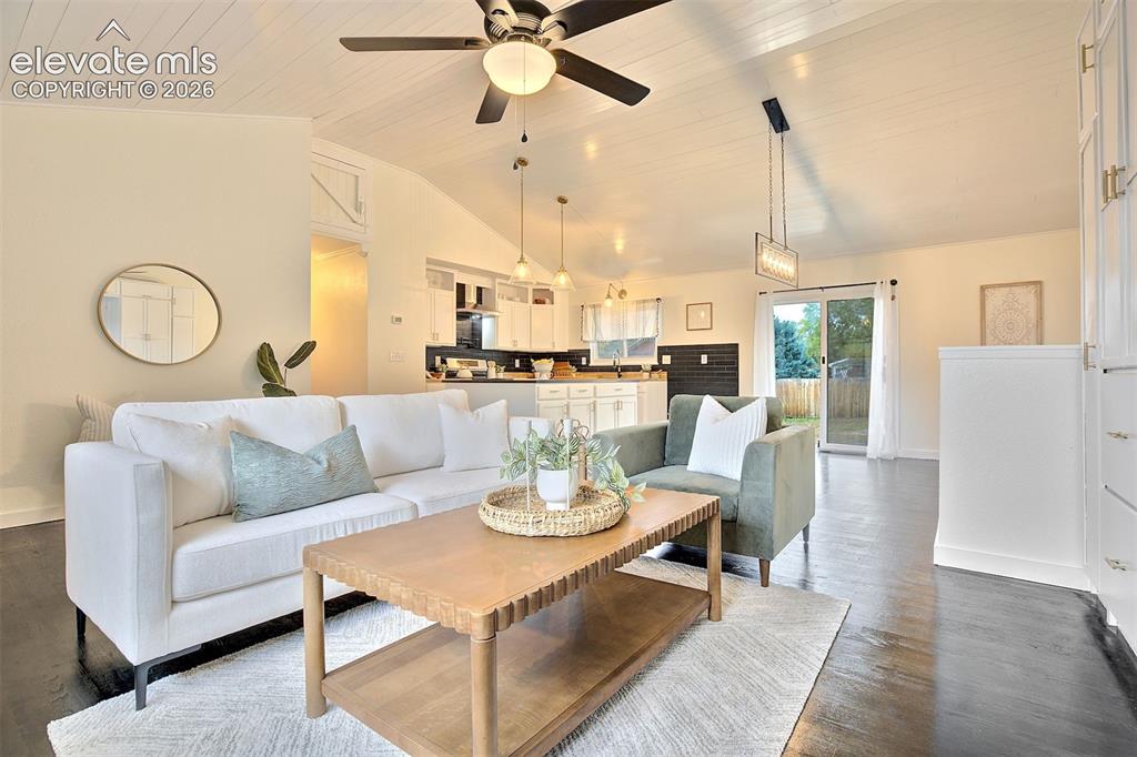 Image 5 of 43: Vaulted ceiling with shiplap detailing, dark wood-finish flooring, recessed