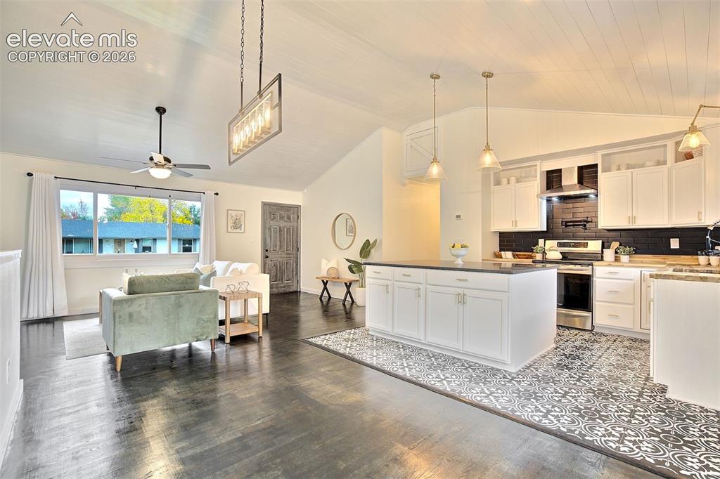 Image 8 of 43: Vaulted ceilings, kitchen island with stone-finish countertop, patterned ti