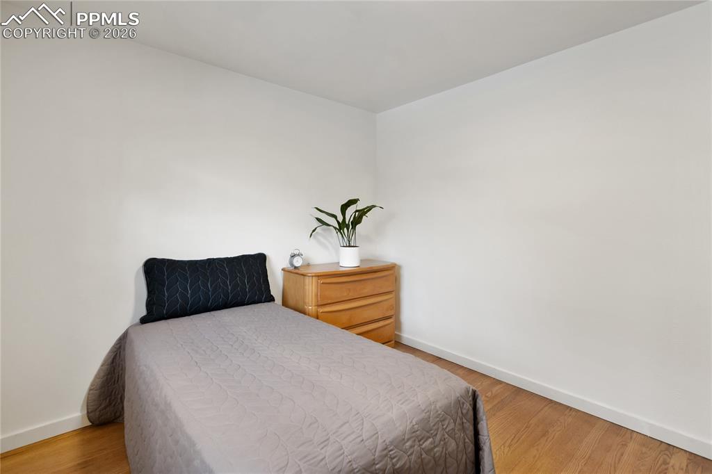 Image 18 of 37: One of 3 bedrooms on the main level.  Refinished hardwood flooring, new doo