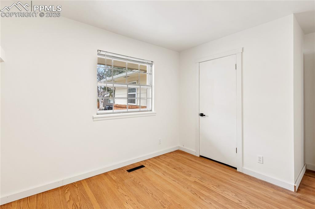 Image 19 of 37: One of 3 bedrooms on the main level.  Refinished hardwood flooring, new doo