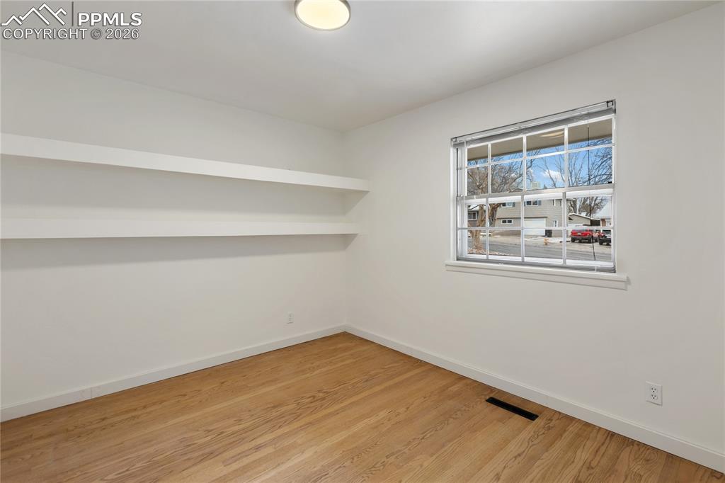 Image 20 of 37: One of 3 bedrooms on the main level.  Refinished hardwood flooring, new doo