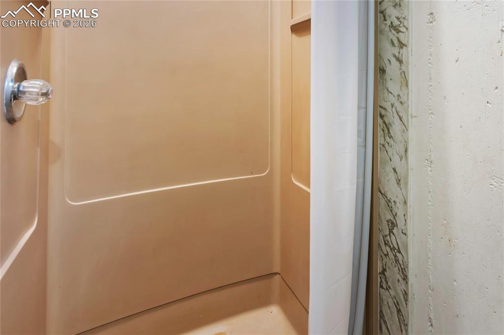 Image 31 of 37: Basement laundry room includes this shower.  Convenient for guests as it is