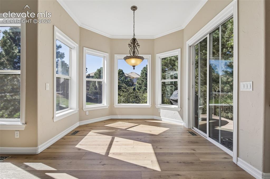 Image 14 of 49: Bay window with five individual windows, wood-finish flooring, sliding glas