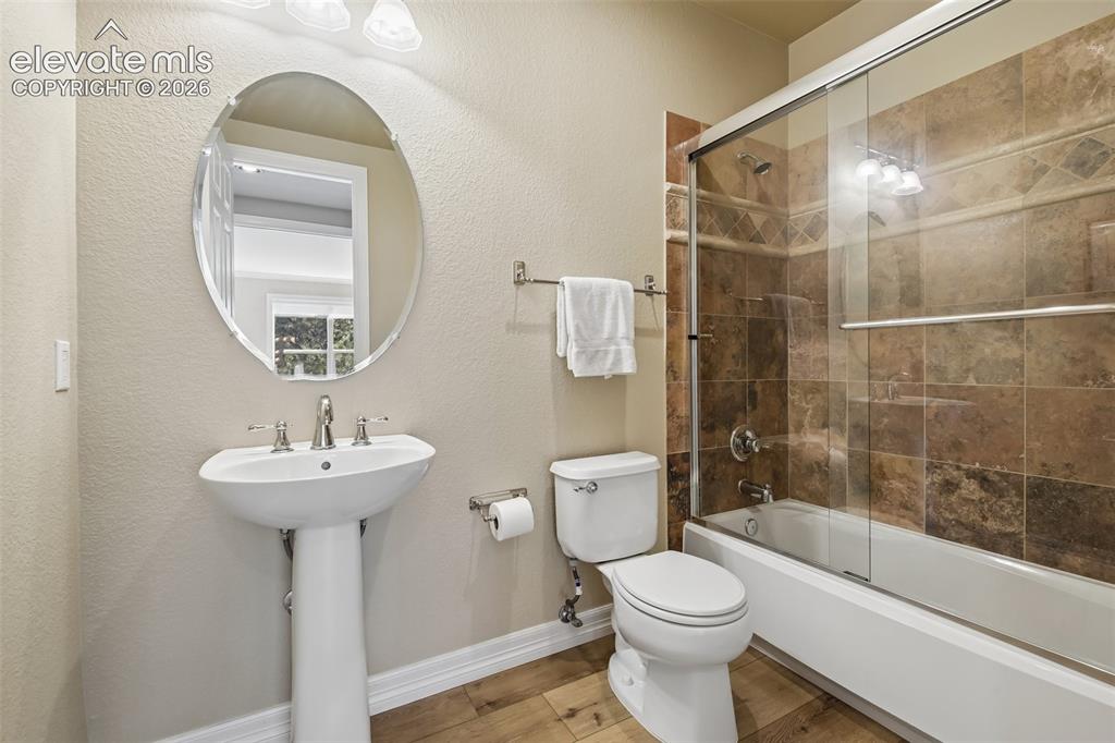 Image 15 of 49: Bathroom featuring wood-finish flooring, a white pedestal sink with a chrom