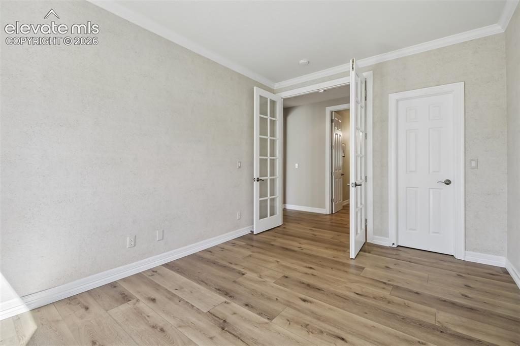 Image 17 of 49: Wood-finish flooring, textured wall finish, white crown molding, white base