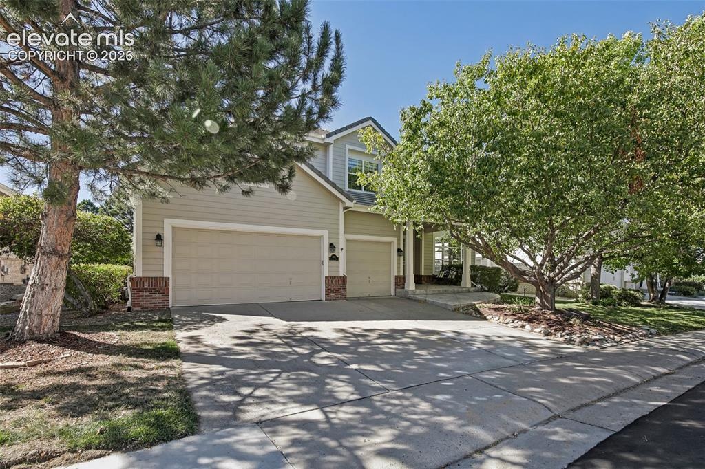 Image 2 of 49: Two-story residence featuring a two-car garage, brick accents, and a covere