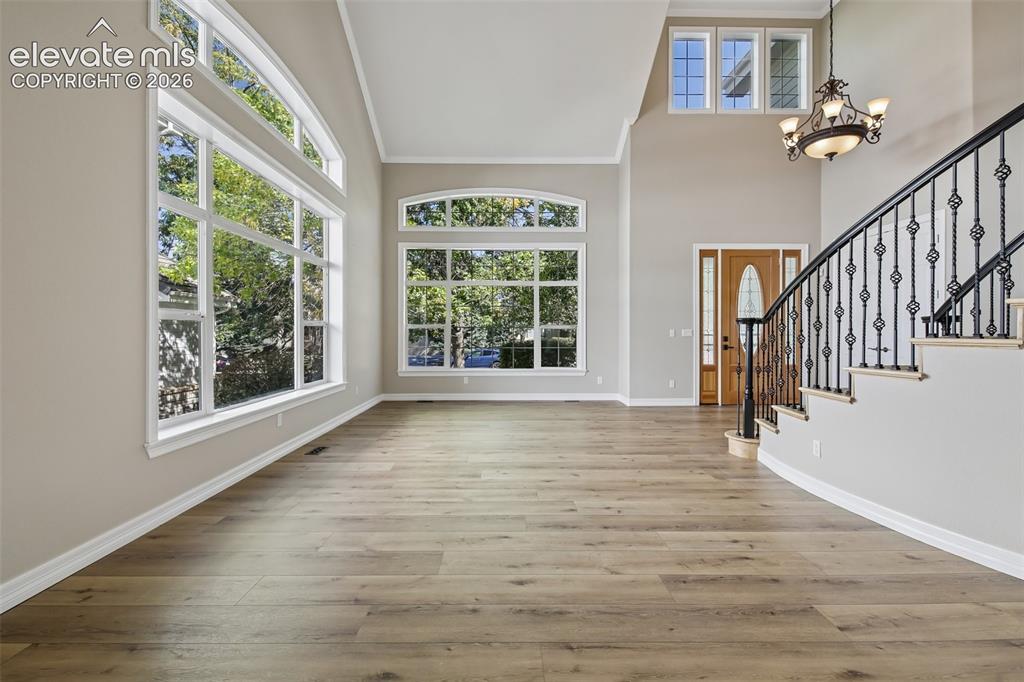 Image 6 of 49: Vaulted ceiling with a decorative chandelier, expansive windows with arch d