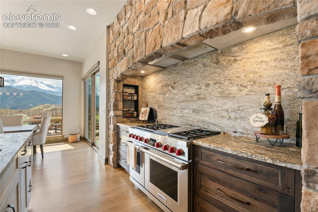 Image 16 of 50: 48-inch Wolf 6-burner range with griddle and double oven, framed by floor-t