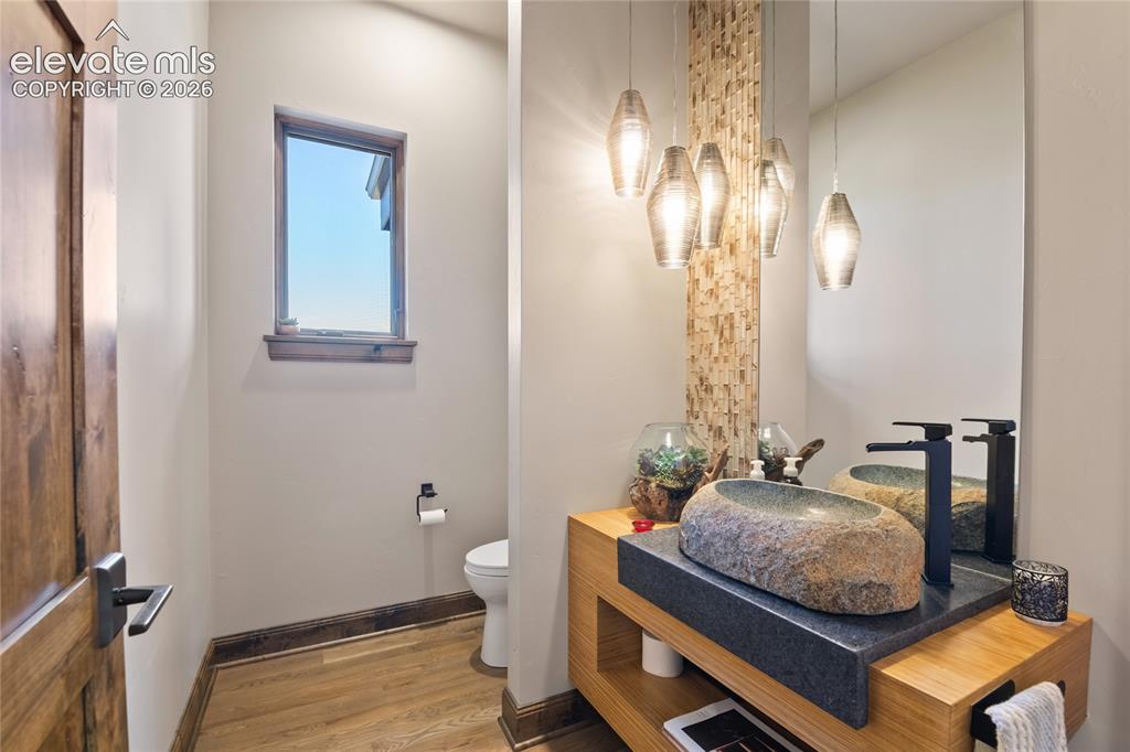 Image 20 of 50: Designer powder room featuring dual natural stone vessel sinks, mosaic tile