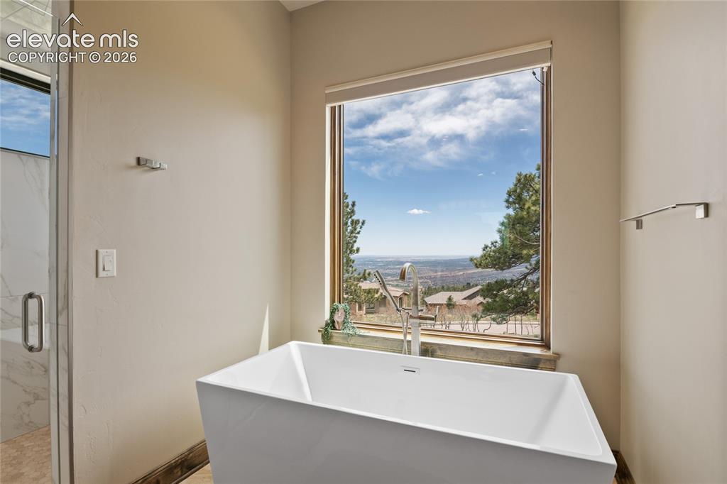 Image 26 of 50: Soak in the skyline. Deep freestanding soaking tub positioned at a private