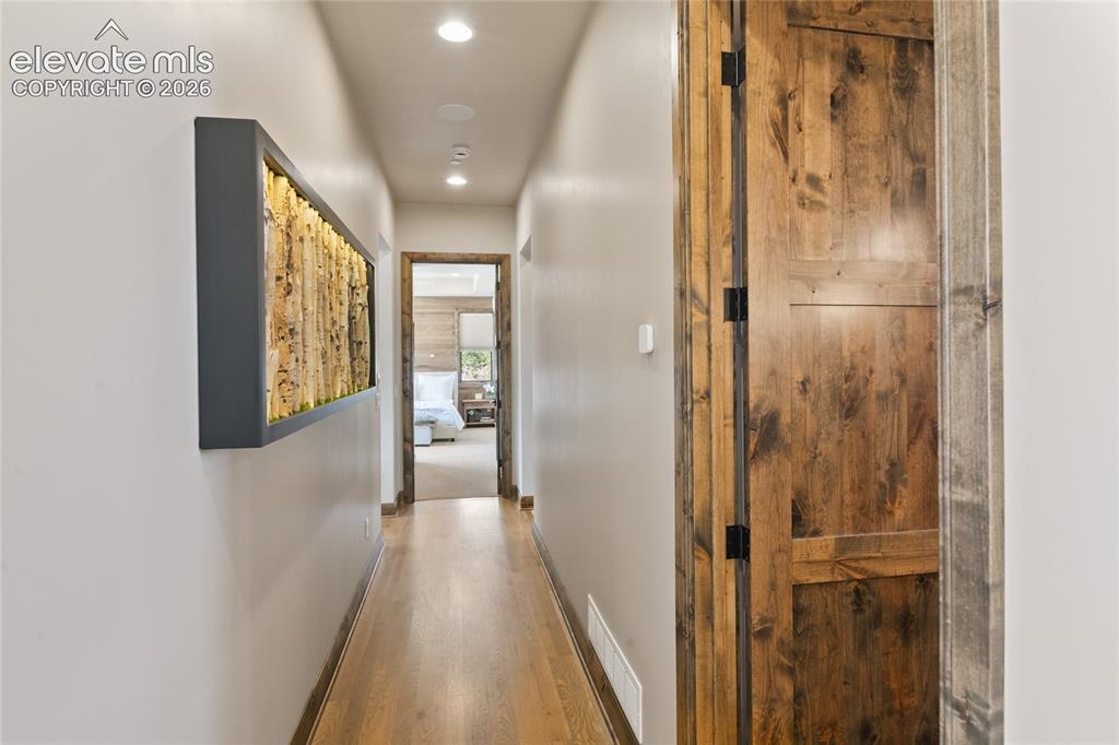 Image 28 of 50: Hallway to private junior suite with powder room on the right.