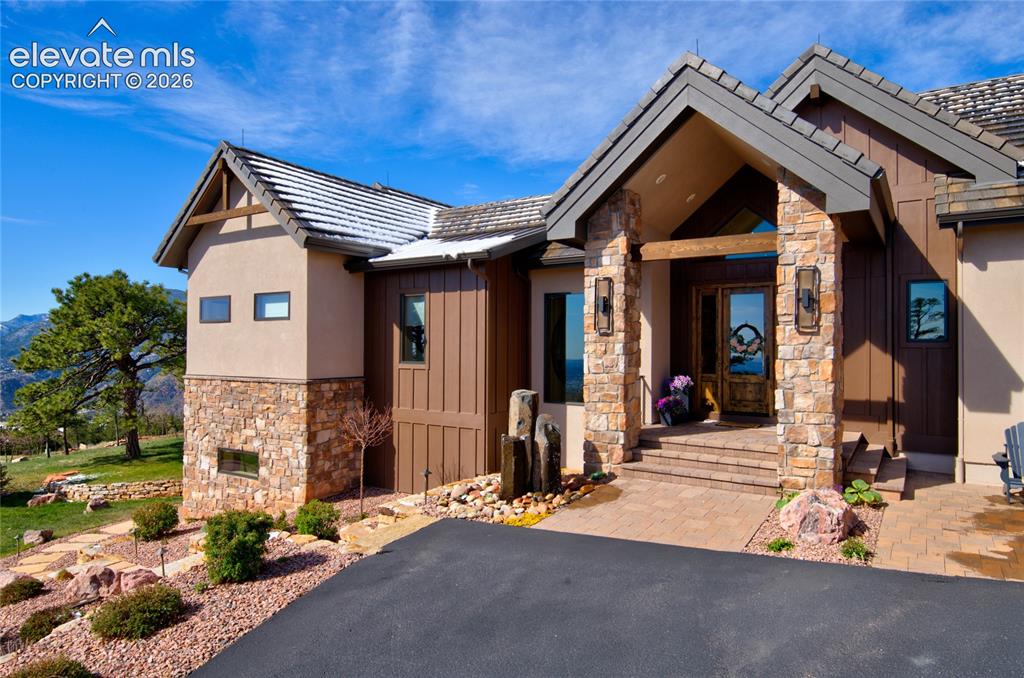 Image 3 of 50: Welcome home. Distinctive front elevation showcasing custom stone columns,