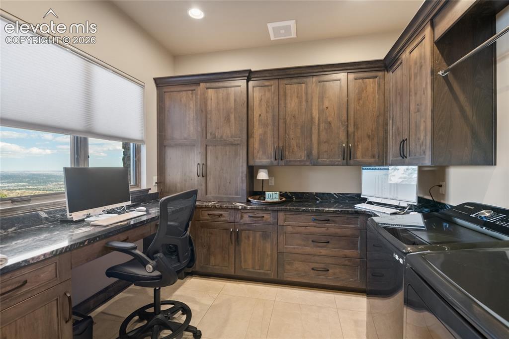 Image 32 of 50: Who said laundry day had to be boring? Dual-purpose office and laundry room