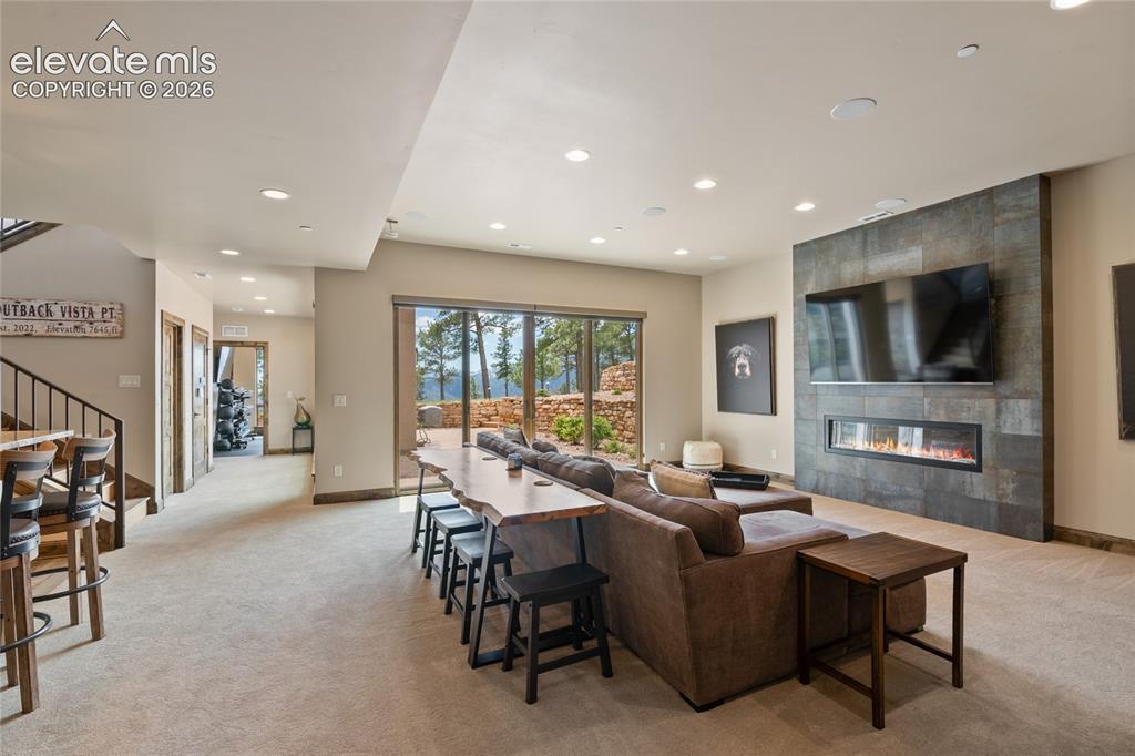 Image 35 of 50: Made for hosting. Expansive lower-level family room with double-sided firep