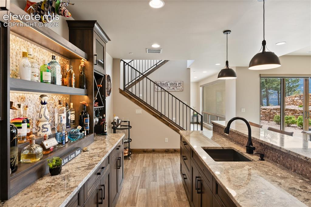 Image 38 of 50: Pour one for the host. Lower-level wet bar featuring full-height liquor dis