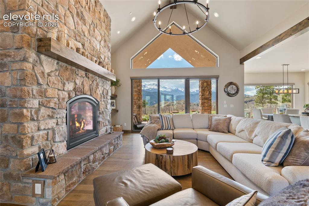 Image 6 of 50: Soaring vaulted great room with floor-to-ceiling stone gas fireplace, white