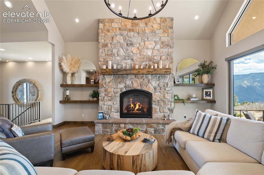 Image 7 of 50: Floor-to-ceiling stonework. Hand-hewn mantel. Mountain views out every wind