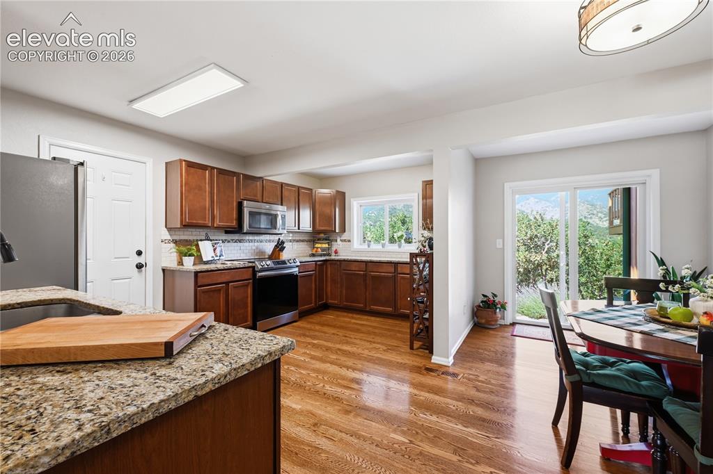 Image 10 of 44: Kitchen and Dining area view showing walk out from dining area to back yard